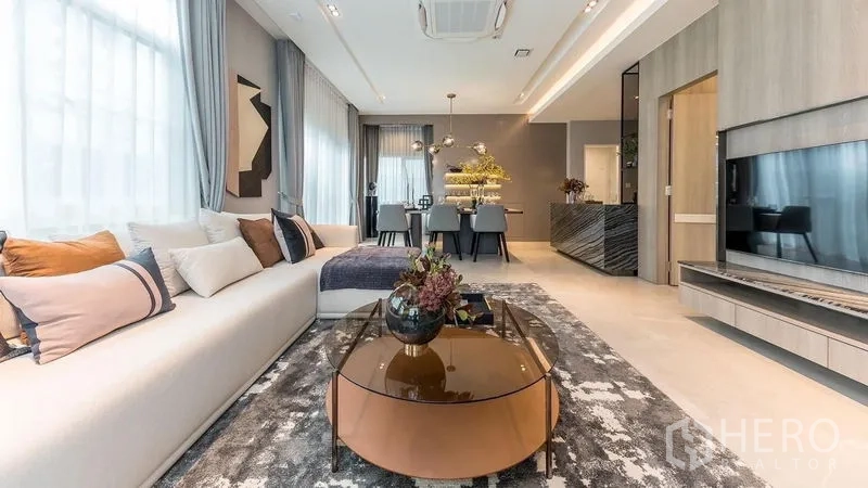 บ้าน ให้เช่าในPrawet, Bangkok - ห้องนั่งเล่นมีโซฟาทรงยาว โต๊ะกลางกลม และผนังทีวีบิลท์อิน