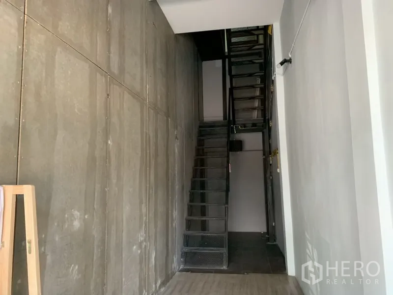 店屋 出租在Watthana, Bangkok - 工业风楼梯间，裸露混凝土墙与钢制台阶。