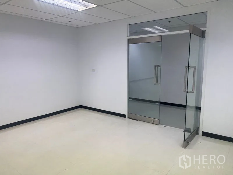 Office Space for rent in Watthana, Bangkok - Clean corner workspace with double glass doors and smooth light tile flooring.
