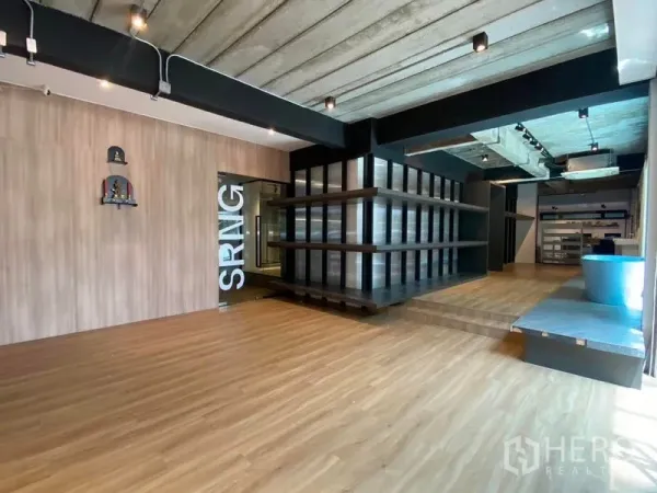 Home Office for rent in Wang Thonglang, Bangkok - Open ground floor with wood floors, exposed concrete ceiling, shelves and track lighting