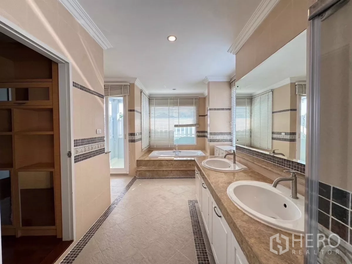 Detached House for rent or sale in Prawet, Bangkok - Spacious bathroom with double vanity, soaking tub and a large mirror.