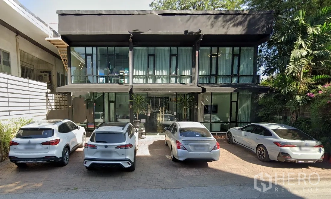 Retail Space for rent in Watthana, Bangkok - Two-storey glass-front retail building with shaded entries and on-site parking.