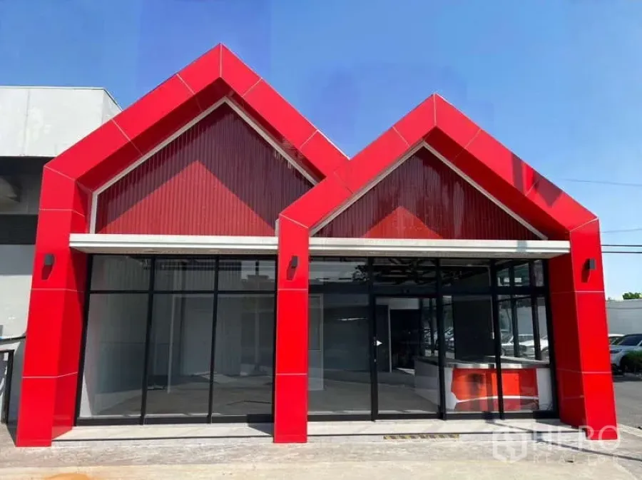 Retail Space for rent - Modern retail unit with striking red twin‑gable facade and full-height glass frontage.