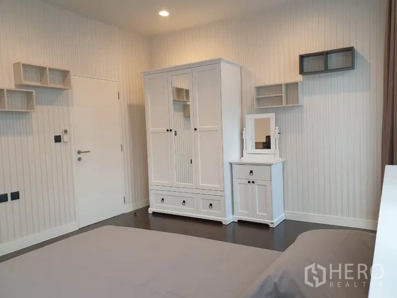 Detached House for rent in Bang Kapi, Bangkok - Bedroom wall with white wardrobe, vanity cabinet, and floating shelves.