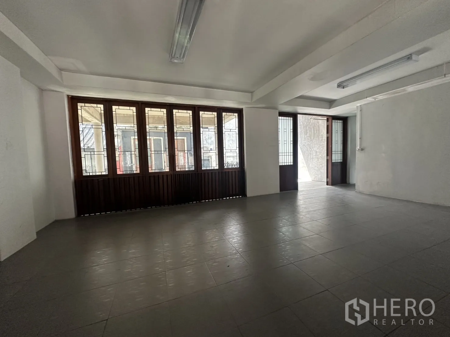 Home Office for rent in Pathum Wan, Bangkok - Large open room with multiple wood-framed windows and access to a terrace.