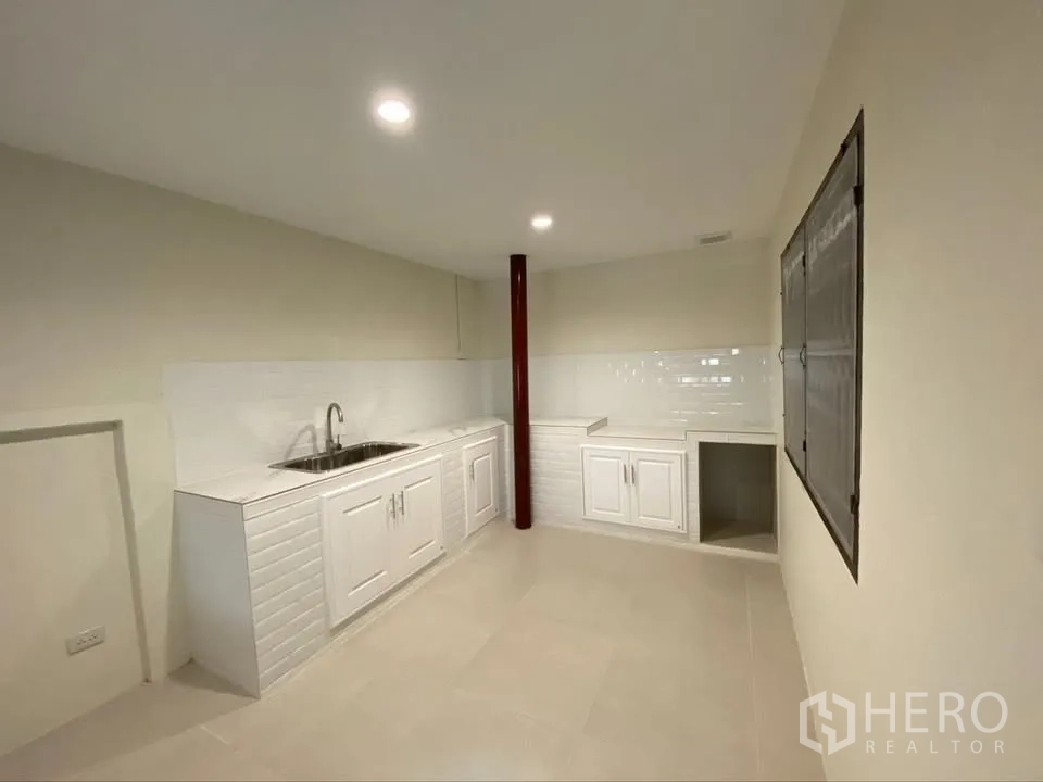 独栋房屋 for rent in Suan Luang, Bangkok - 明亮厨房设有白色橱柜、水槽与防溅瓷砖墙面。