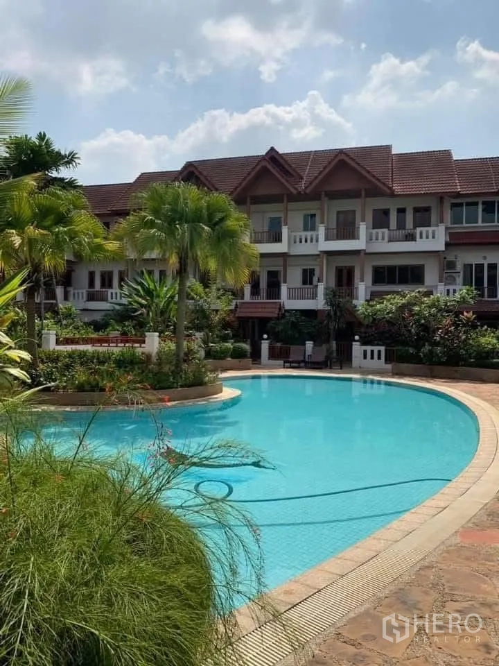 Townhouse for rent in Watthana, Bangkok - Large communal swimming pool surrounded by gardens and townhouses.