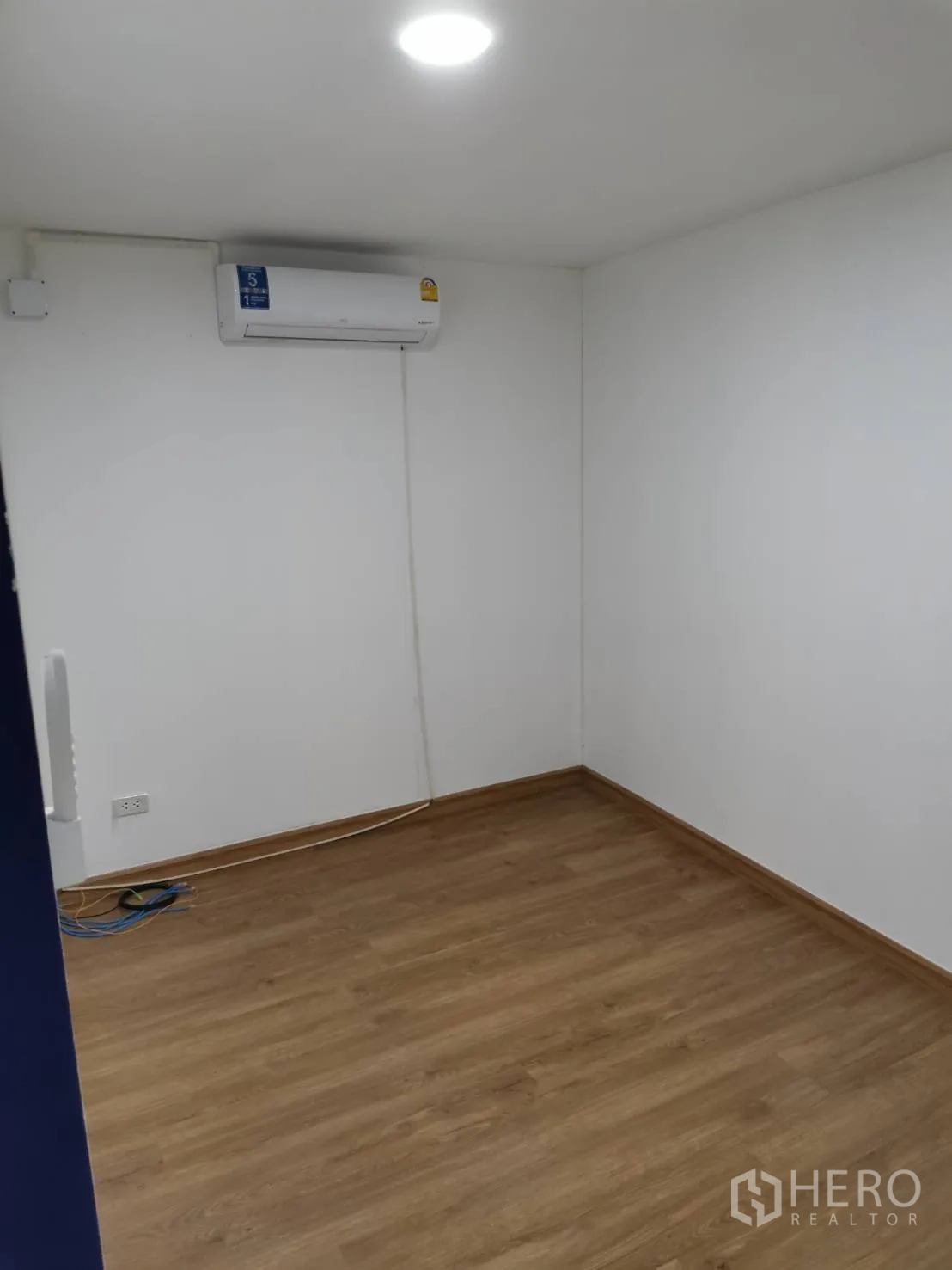 Warehouse for rent in Suan Luang, Bangkok - Enclosed office room with wood-look flooring, air-conditioning, and a ceiling light.