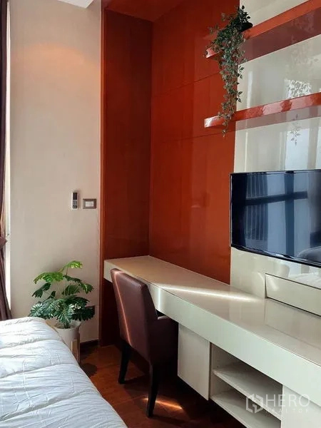 Condominium for rent in Khlong Toei, Bangkok - Bedroom work corner with built‑in desk, wall‑mounted TV, and chair.