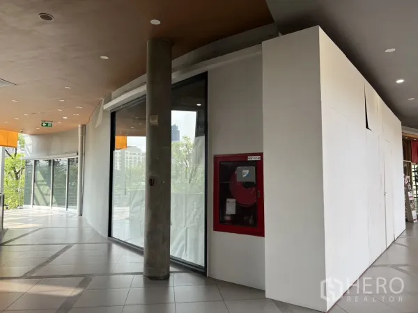 Retail Space for rent in Khlong Toei, Bangkok - Corner retail unit showing rounded glass facade, concrete column and safety equipment.