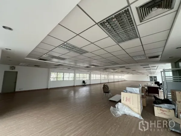 Office Space for rent in Watthana, Bangkok - Open office area with boxes near the entrance, vinyl floors and air-conditioned ceiling.