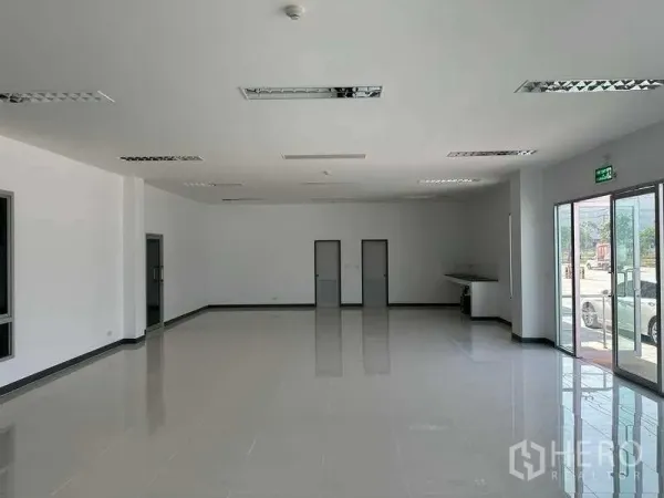 Factory for rent in Bang Sao Thong, Samut Prakan - Open-plan office area with glossy floors, fluorescent lighting and multiple internal doors.