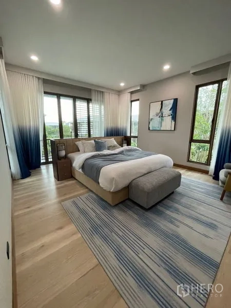 Detached House for sale in Bang Kapi, Bangkok - Primary bedroom with large windows, soft-toned décor and a plush area rug.