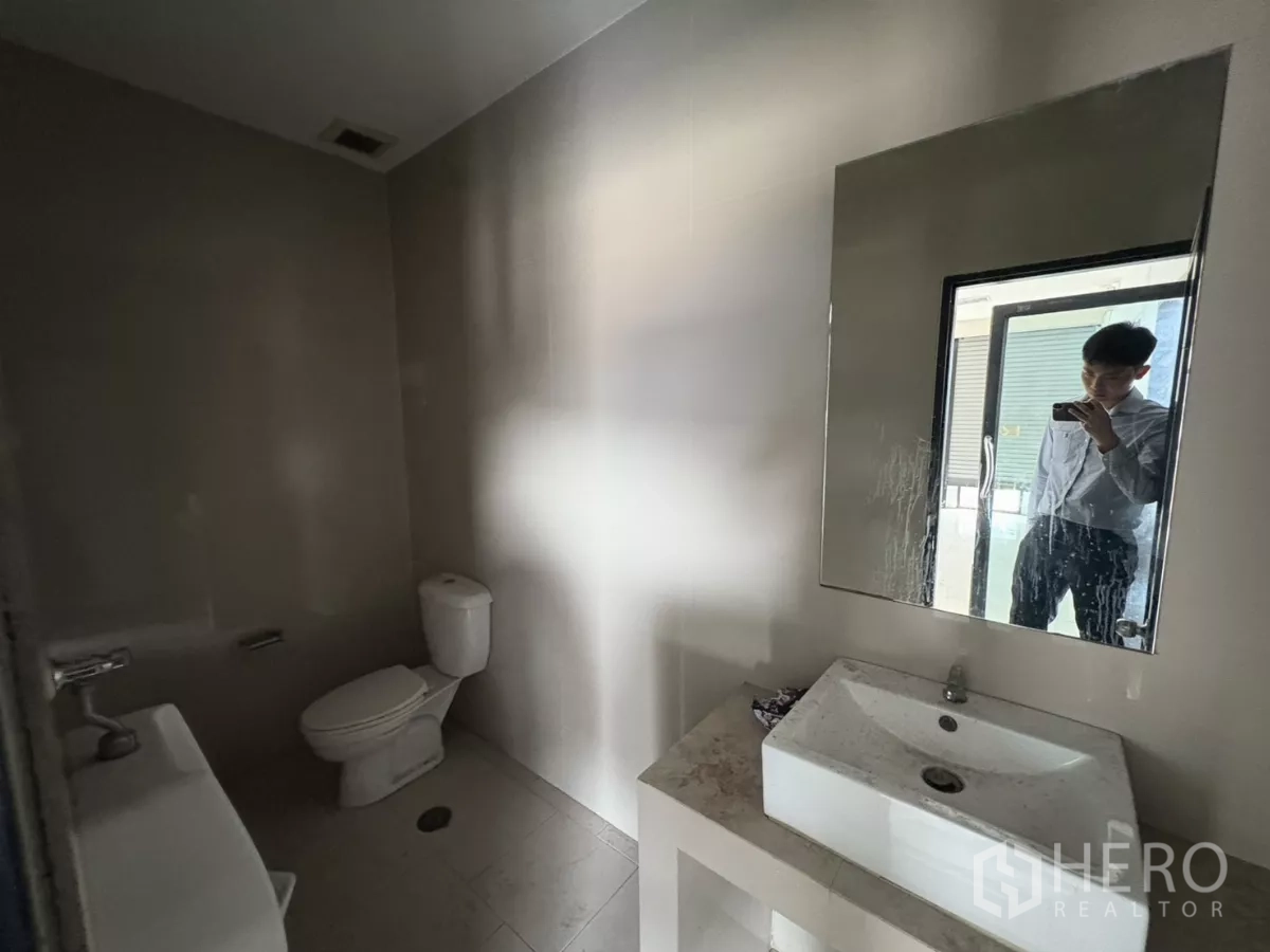 Warehouse for rent in Bang Phli, Samut Prakan - Clean restroom with toilet, sink, and mirror inside the office area.