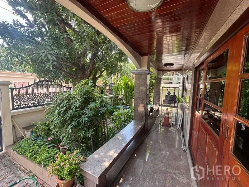 Detached House for sale in Suan Luang, Bangkok - Covered terrace with polished ceiling, stone columns and lush garden.
