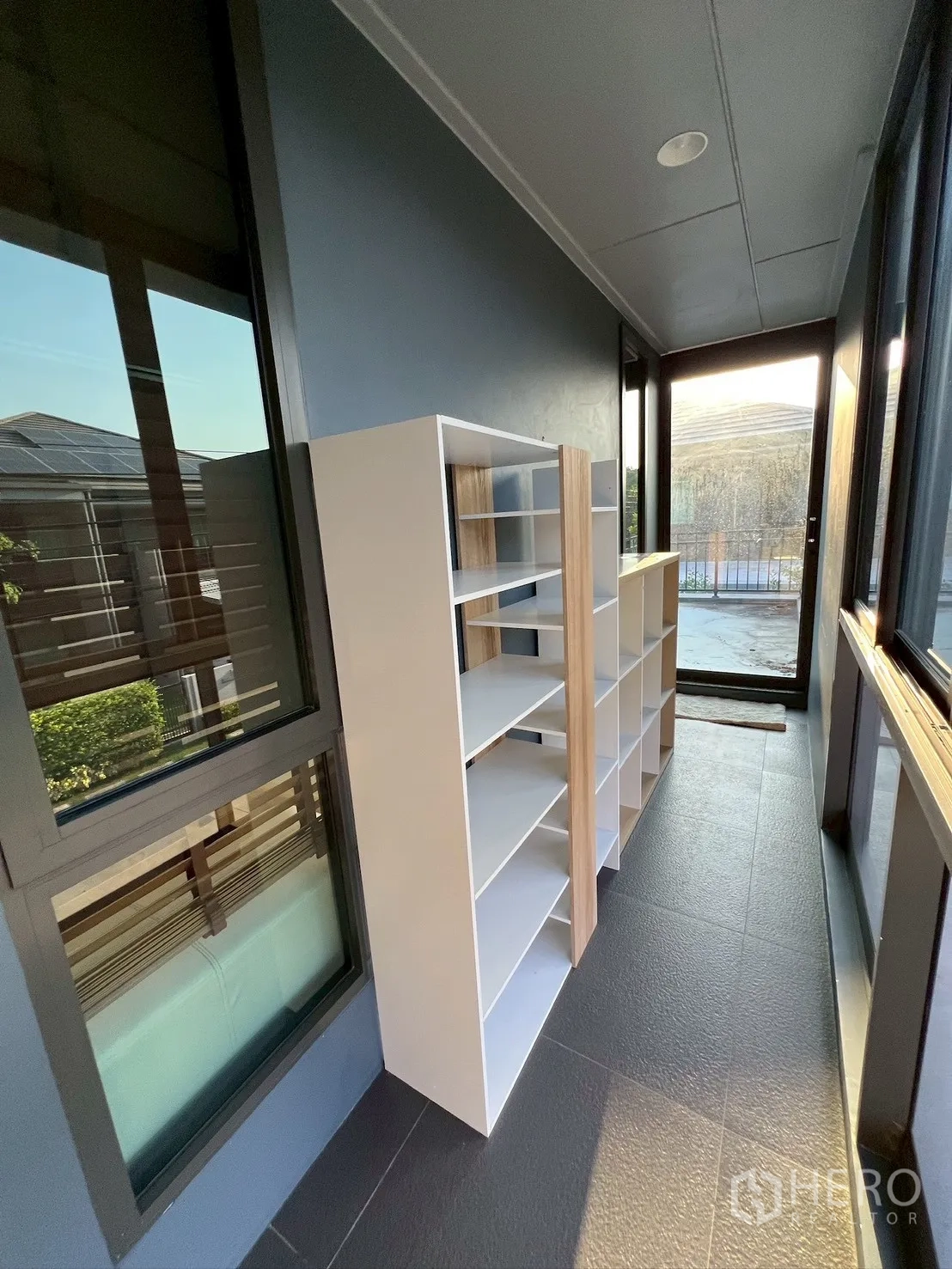Detached House for rent in Bang Kapi, Bangkok - Narrow balcony corridor with open shelving units and sliding door.