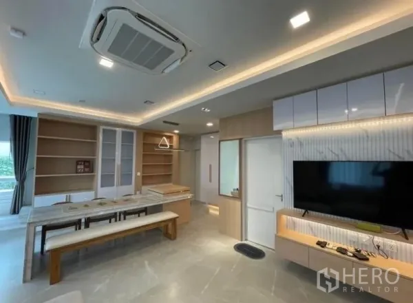 Detached House for rent in Prawet, Bangkok - Open-plan dining and lounge with built-in shelves, TV wall and ceiling cassette air conditioner.