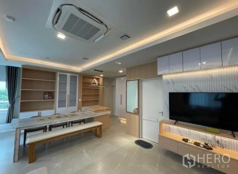 Detached House for rent in Prawet, Bangkok - Open-plan dining and lounge with built-in shelves, TV wall and ceiling cassette air conditioner.