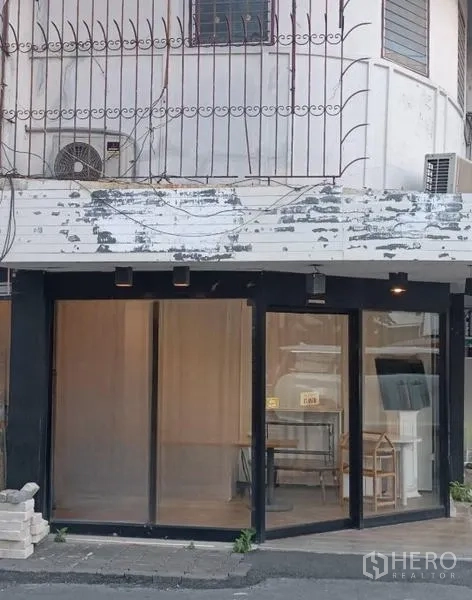 Retail Space for rent in Watthana, Bangkok - Corner retail frontage with floor-to-ceiling glass and black frame on a main Thonglor street.