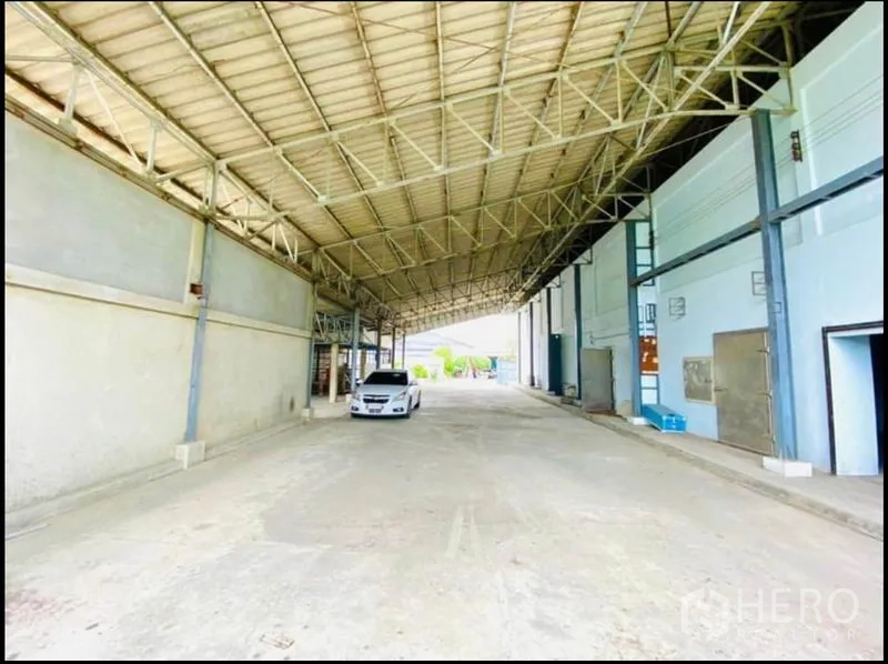 Factory for rent in Sam Phran, Nakhon Pathom - Covered drive-through loading area with steel truss roof and ample truck clearance.