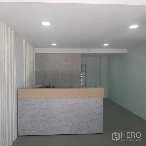 Home Office for rent or sale in Suan Luang, Bangkok - Minimalist reception area with a stone counter and recessed lights.