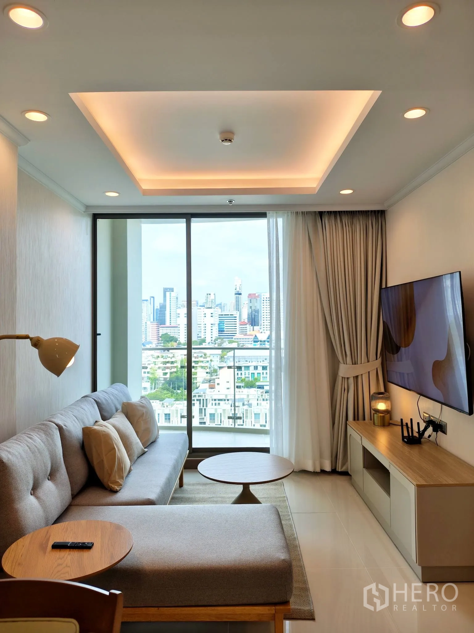 公寓 for rent in Watthana, Bangkok - 客厅通往阳台，可观天际线景致，吊顶设有回字灯槽。