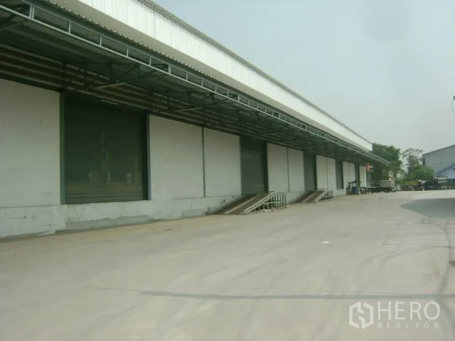 Warehouse for rent in Mueang Samut Sakhon, Samut Sakhon - Wide driveway in front of covered loading docks with roller doors for easy truck maneuvering.
