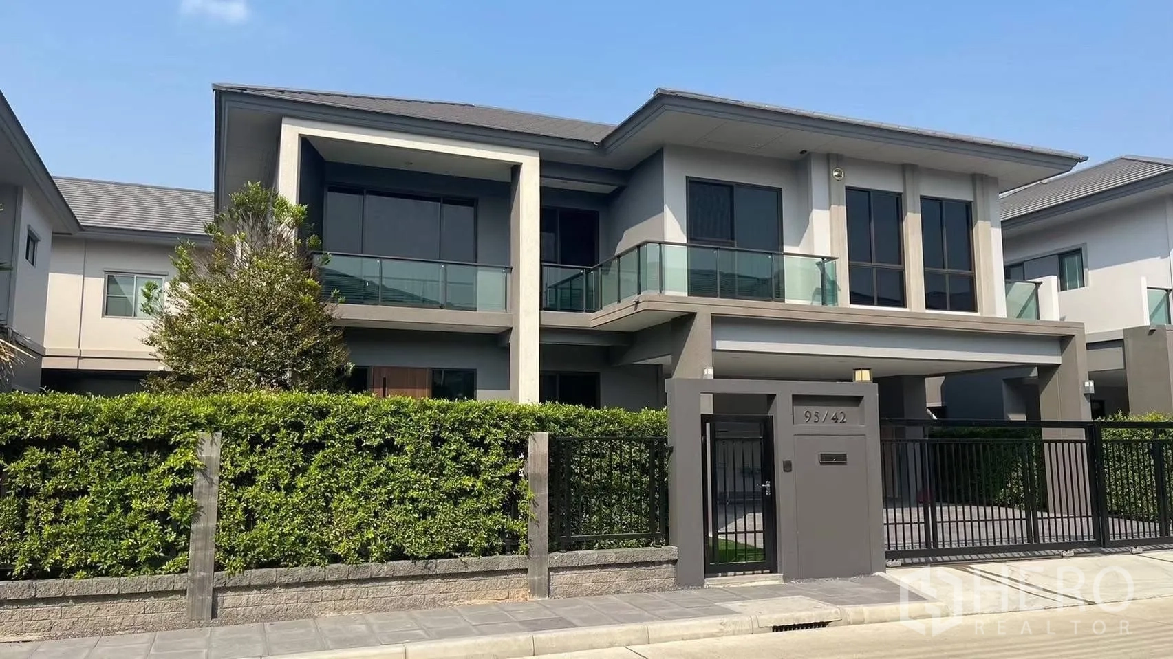 独栋房屋 for rent in Prawet, Bangkok - 街景视角的两层独栋别墅，带前院围栏与大门。