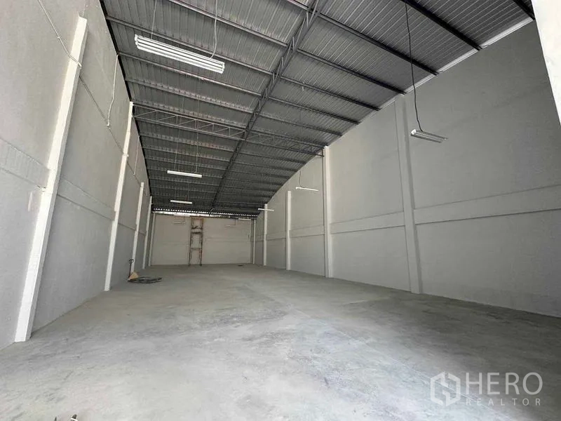 Warehouse for rent in Mueang Samut Sakhon, Samut Sakhon - Clean warehouse space with high metal roof, white walls, and even concrete floor.