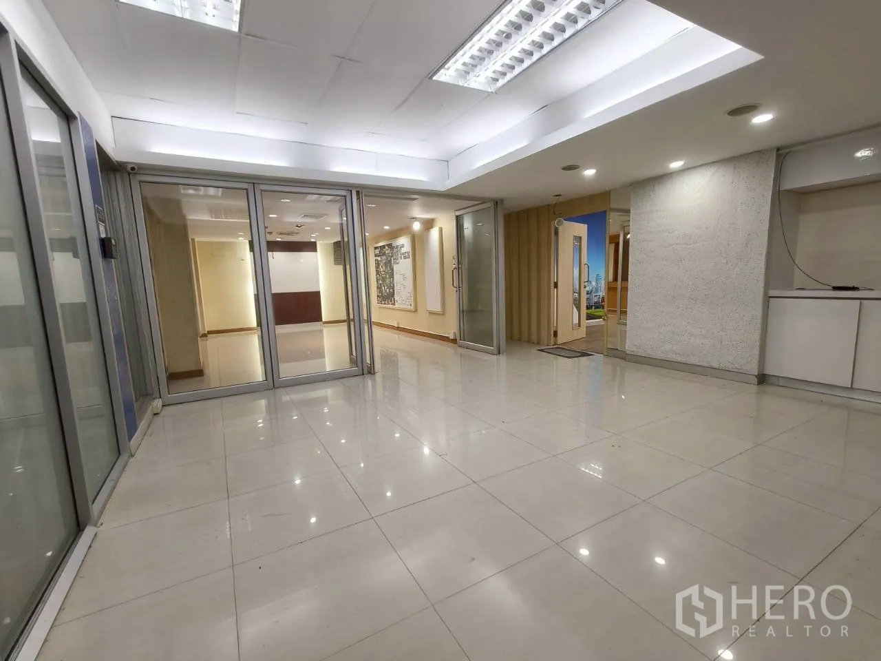 Office Space for rent in Chatuchak, Bangkok - Large reception or collaboration zone with tiled floors and multiple glass partitions.