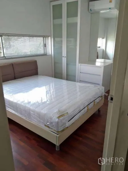 Detached House for rent in Bang Kruai, Nonthaburi - Bright bedroom with double bed, glass-door wardrobe and wooden floor in a Bang Kruai detached house.