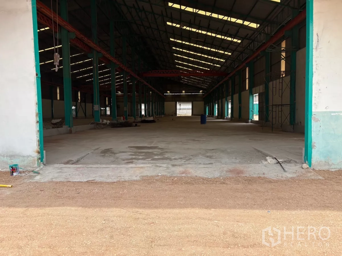 Factory for rent in Mueang Samut Sakhon, Samut Sakhon - Drive-in loading bay showing expansive concrete production space inside the factory.