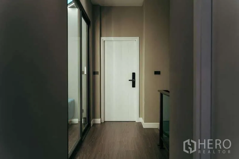 Detached House for sale in Sai Mai, Bangkok - Upper hallway with wood flooring, white door and a glass partition.