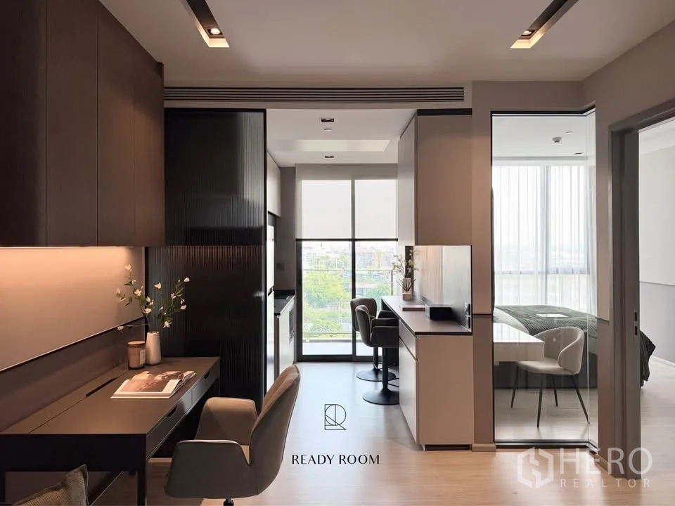 Condominium for rent in Khlong Toei, Bangkok - Bright living space leading to the bedroom through sliding glass and a balcony beyond.