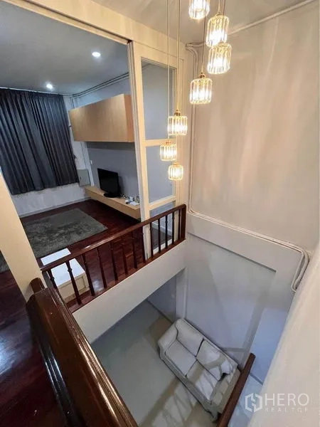 Townhouse for rent in Khlong Toei, Bangkok - Stair landing with contemporary pendant lights overlooking the living space and TV room.