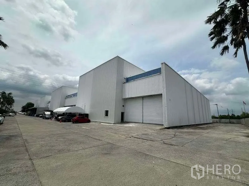 工厂 出租在Khlong Luang, Pathum Thani - 孔龙鲁昂区现代白色工厂外观，配大卷闸门与宽阔卡车车道。