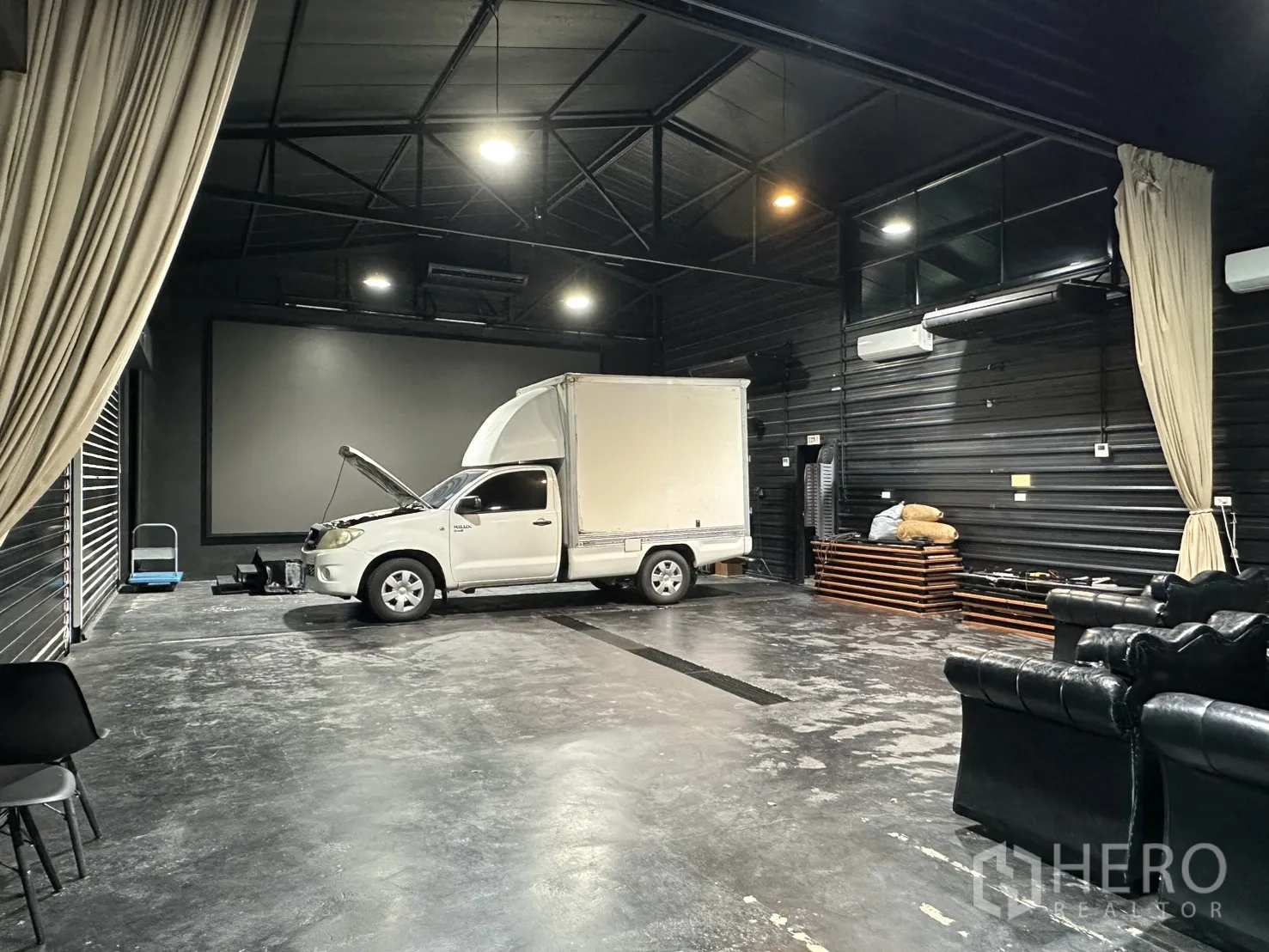 Warehouse for rent in Phra Khanong, Bangkok - Open-plan storage bay with loading truck, roller shutters, and overhead lighting.