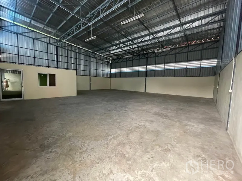 Warehouse for rent in Khlong Luang, Pathum Thani - High-ceiling warehouse interior with steel trusses and smooth concrete floor.