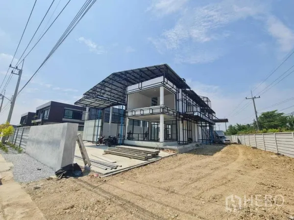 货栈 出租在Bang Len, Nakhon Pathom - 两层钢结构仓库，带高挑遮雨装卸区、宽敞车道与围墙，晴空下外观。