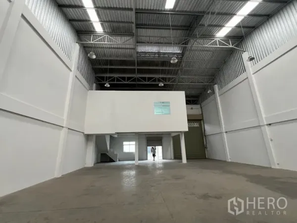 Warehouse for rent in Phra Samut Chedi, Samut Prakan - View toward the loading area with a large roller shutter beneath the mezzanine block.