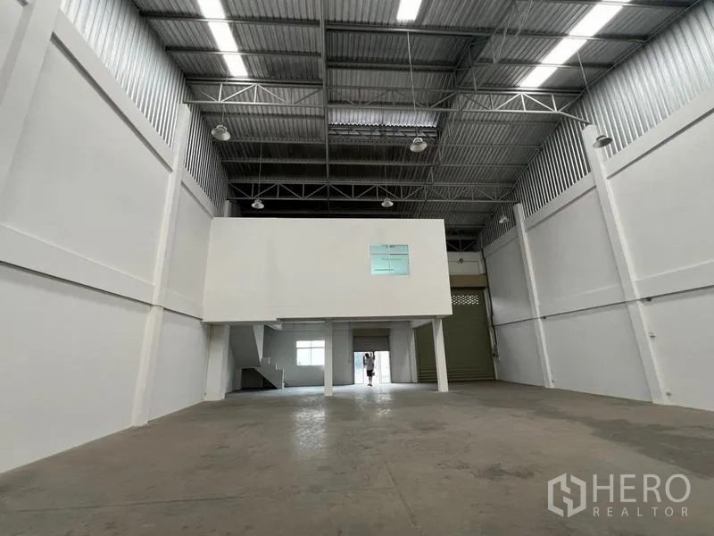 Warehouse for rent in Phra Samut Chedi, Samut Prakan - View toward the loading area with a large roller shutter beneath the mezzanine block.