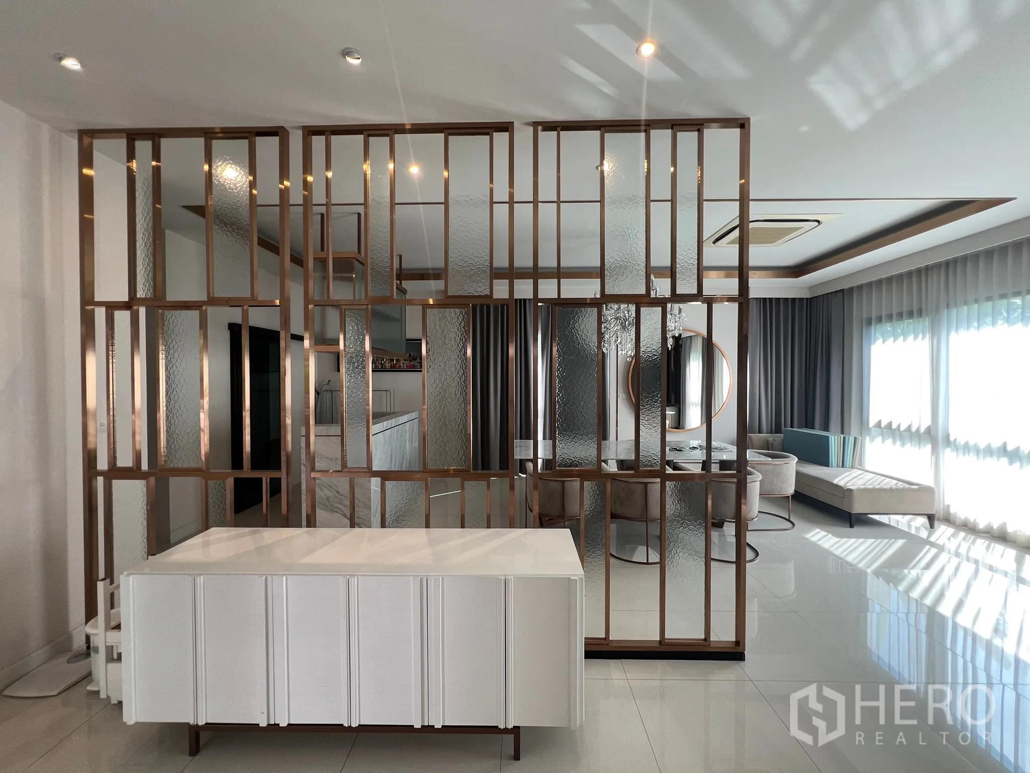 Detached House for rent or sale in Prawet, Bangkok - Decorative glass-and-brass partition separating living and dining zones.