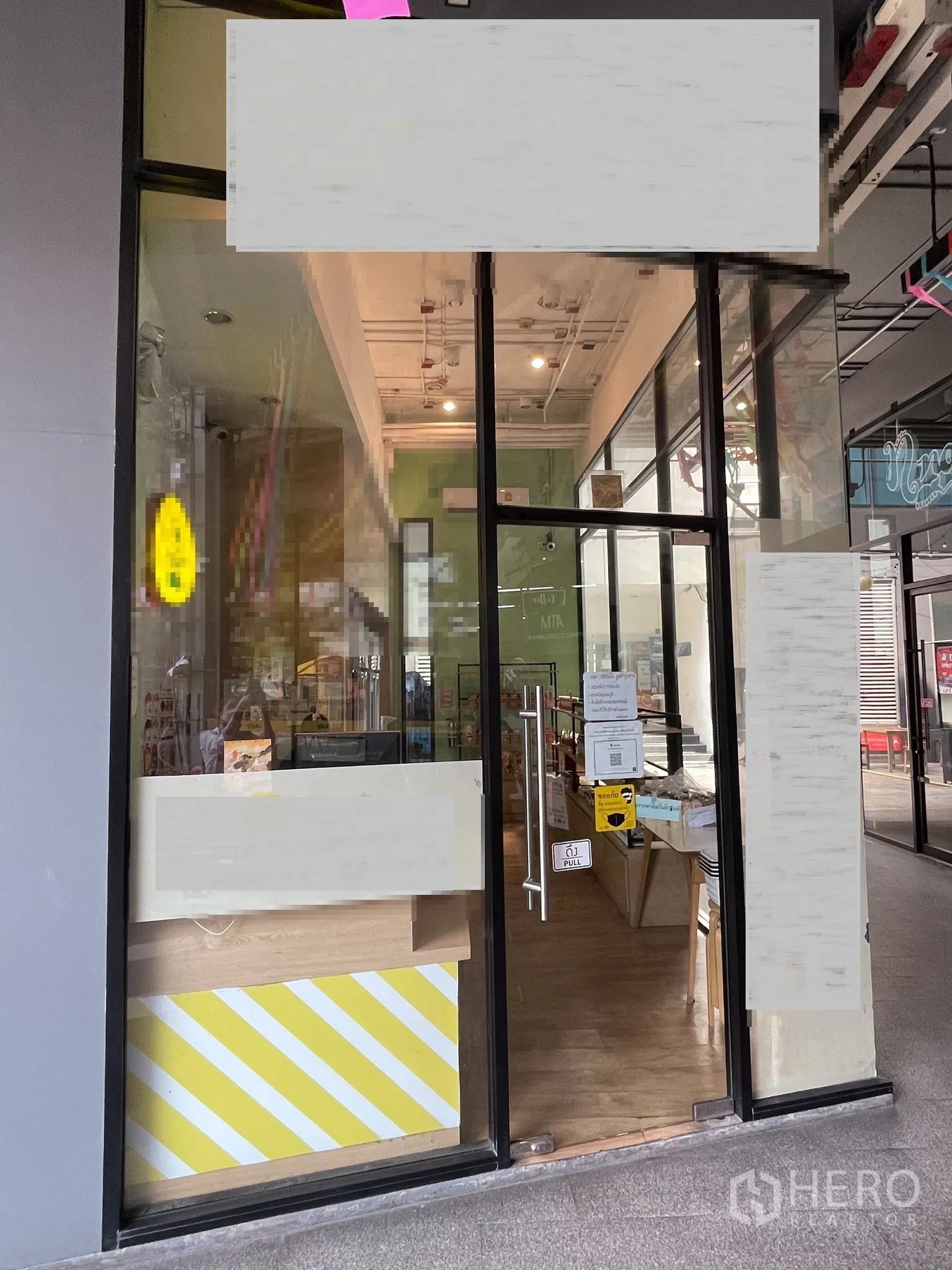 Retail Space for rent in Khlong Toei, Bangkok - Glass entrance door to a compact retail space with high ceiling and wood floors.