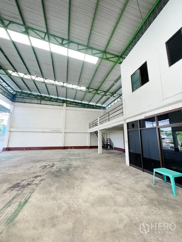 Warehouse for rent or sale in Thanyaburi, Pathum Thani - Warehouse interior showing mezzanine walkway, stair access and glass-partitioned office.
