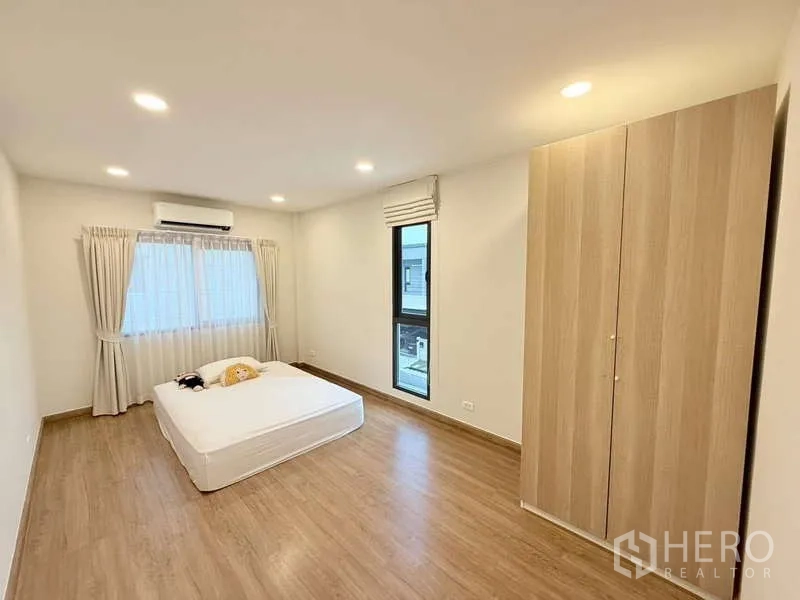 Detached House for sale in Bang Phli, Samut Prakan - Large secondary bedroom with wardrobe, air conditioning and wood floors.