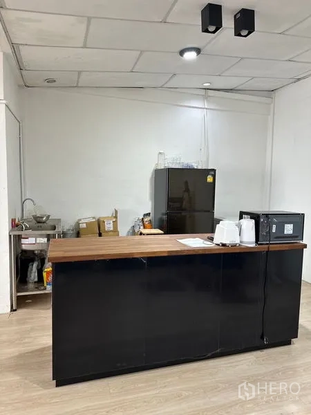 店屋 出租在Khlong Toei, Bangkok - 茶水间，黑色吧台木质台面，冰箱、微波炉与水槽。