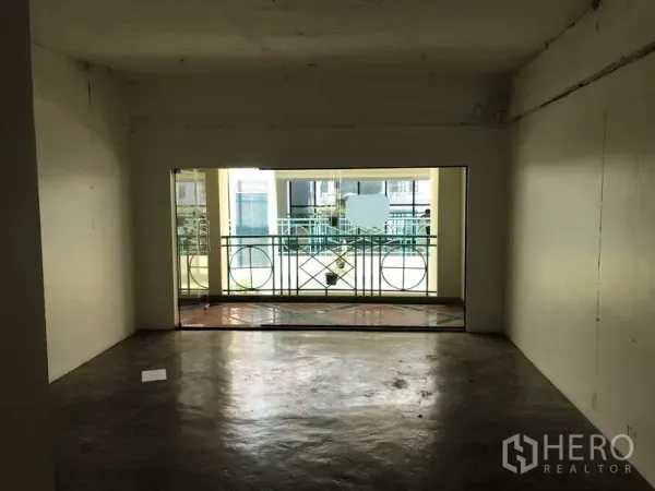 Retail Space for rent in Khlong Toei, Bangkok - Empty open-plan retail unit with polished concrete floor and a balcony railing facing an indoor atrium.