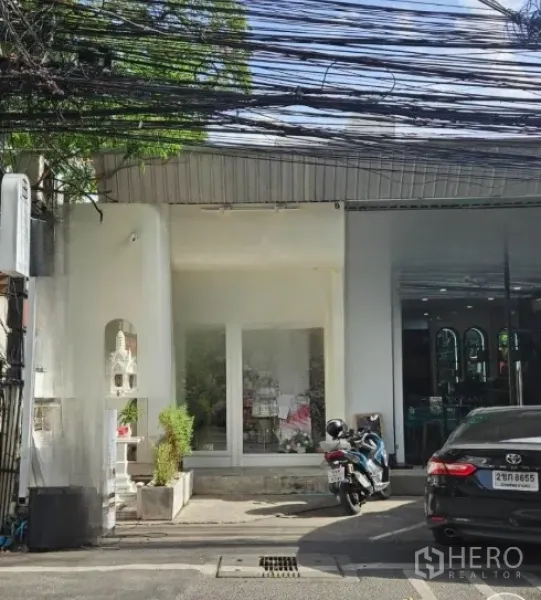 Retail Space for rent in Watthana, Bangkok - Shopfront with wide display windows and a small parking bay on a quiet lane.