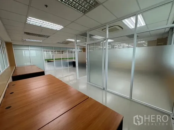 办公空间 出租在Suan Luang, Bangkok - 现代办公室内，玻璃隔断旁设成排木质书桌，采光良好。