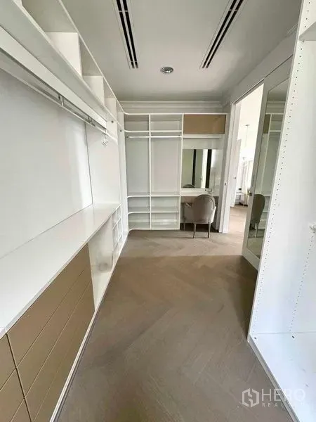 Townhouse for rent in Watthana, Bangkok - Spacious walk-in closet with built-in shelving, drawers and a vanity desk.